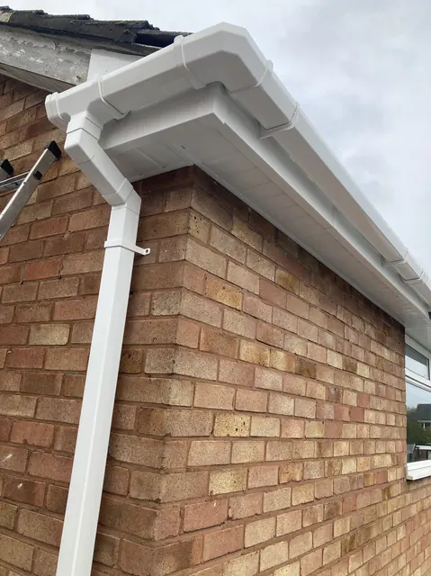 New white uPVC fascia, soffit, guttering and downpipe on a brick house